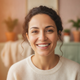 Headshot portrait of a smiling woman in her 30s, looking at the camera with a warm expression.